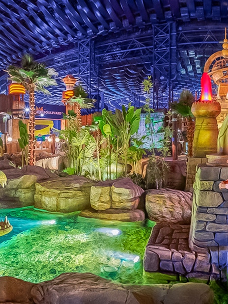 Visitors observing animatronic crocodile at IMG Worlds of Adventure, Dubai indoor theme park.