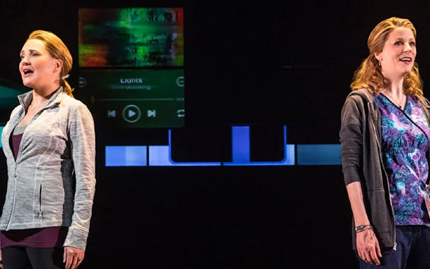 Two performers singing on stage during a scene from Dear Evan Hansen.