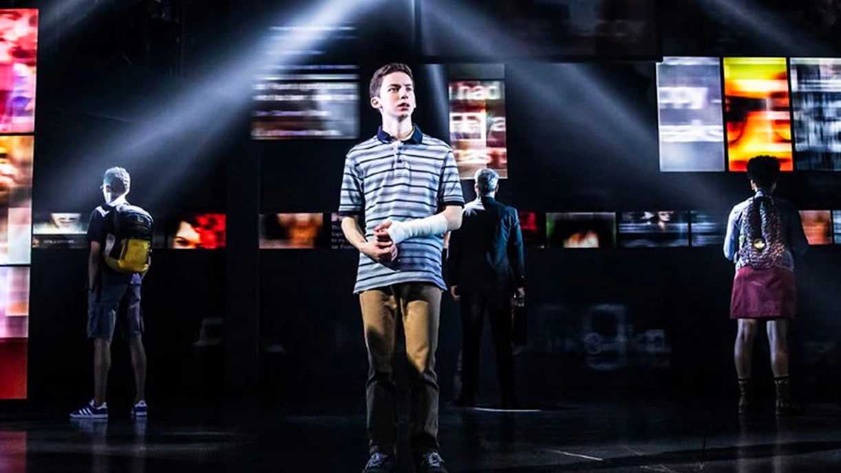 Stage scene from Dear Evan Hansen musical with main character in spotlight.