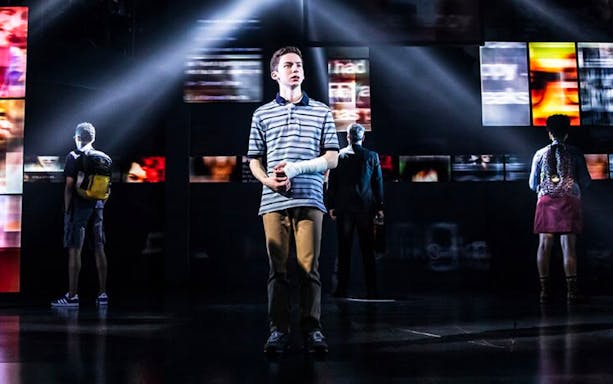 Stage scene from Dear Evan Hansen musical with main character in spotlight.