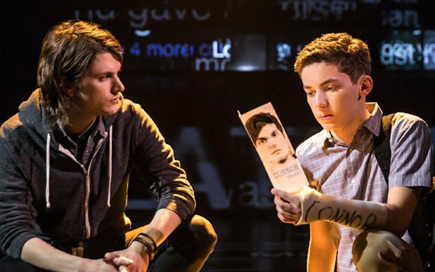 Two actors on stage in a scene from the musical "Dear Evan Hansen," one holding a letter.
