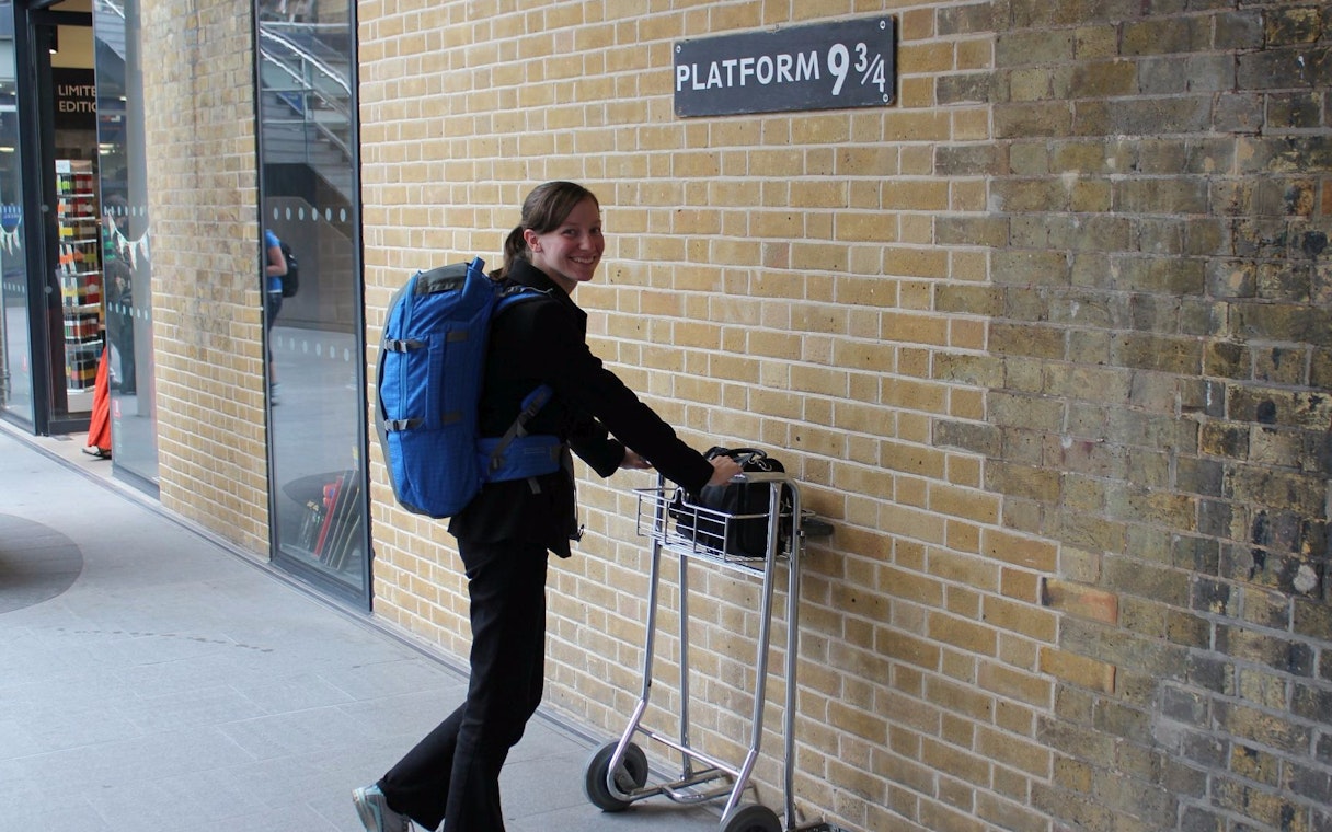 Person with luggage cart at Platform 9¾, King's Cross, London, on Harry Potter bus tour.