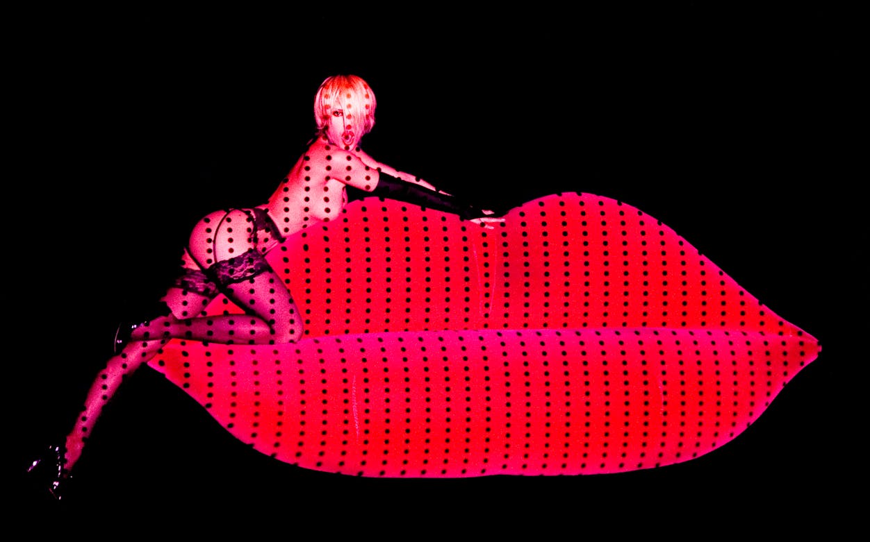 Performer on red lips stage at Crazy Horse Paris.