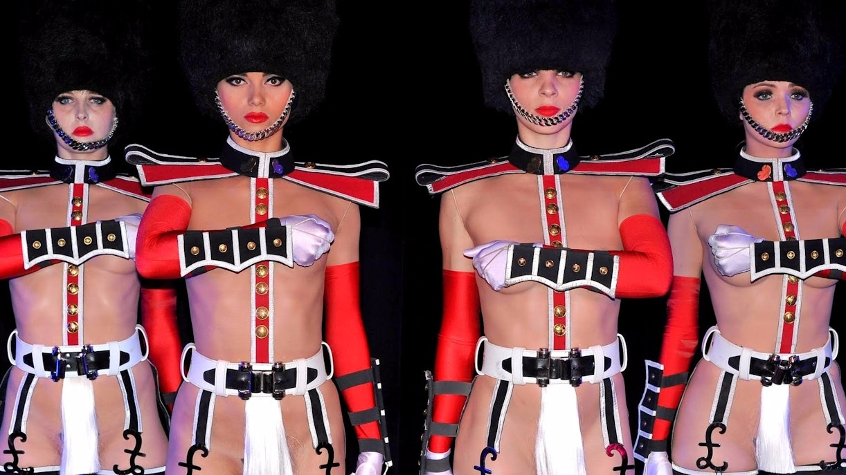 Palco iluminado do cabaré Crazy Horse em Paris, com dançarinas performando em coreografia artística.