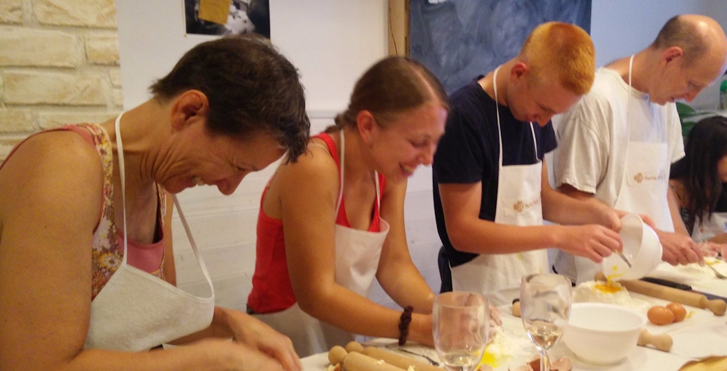 Participants making pasta during a cooking class in Rome.