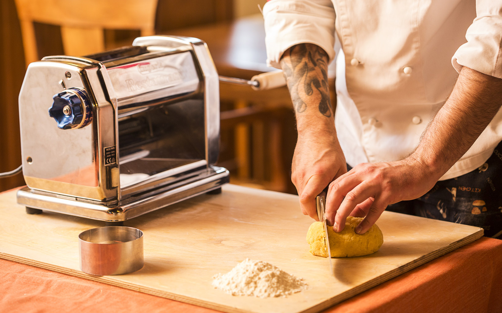 Chef preparing pasta dough with a pasta machine