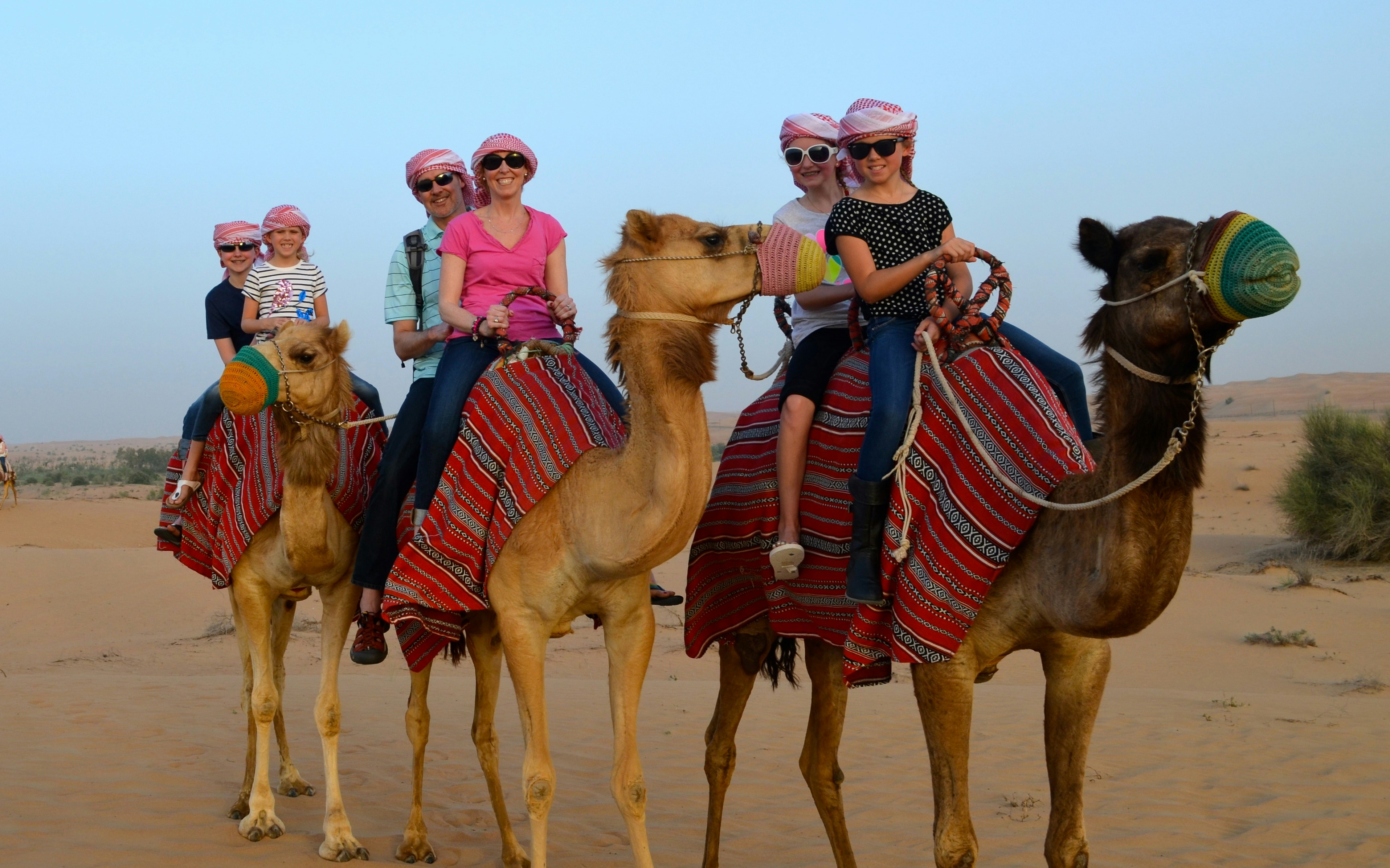 Camel ride in desert with group enjoying Desert Adventure Combo tour.