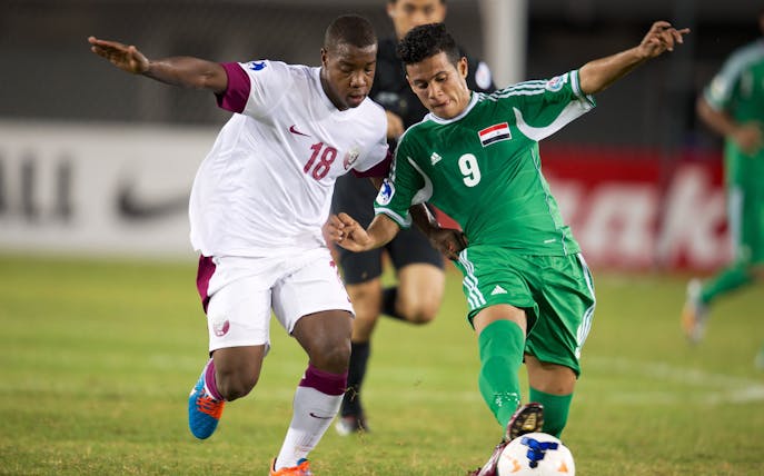 Soccer players from UAE and Iraq competing during 2018 FIFA World Cup Qualification match.