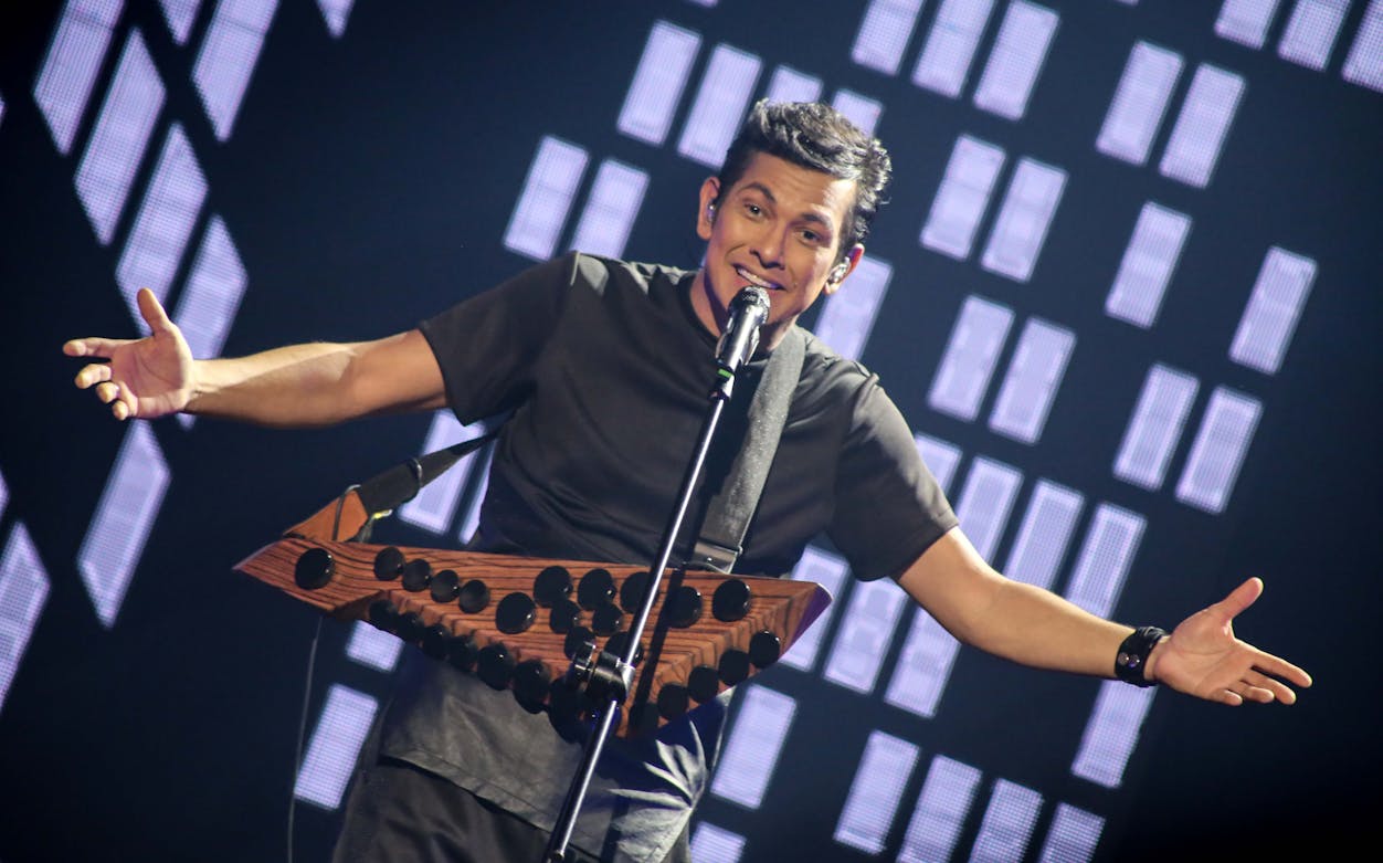 Performer on stage with a unique instrument during a Dubai event.