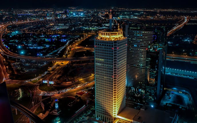 Dubai cityscape at night with illuminated skyscrapers and highways.