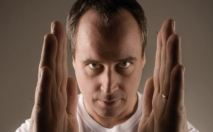 Man with hands raised, focused expression, related to Dysfunktion 1st Birthday event.