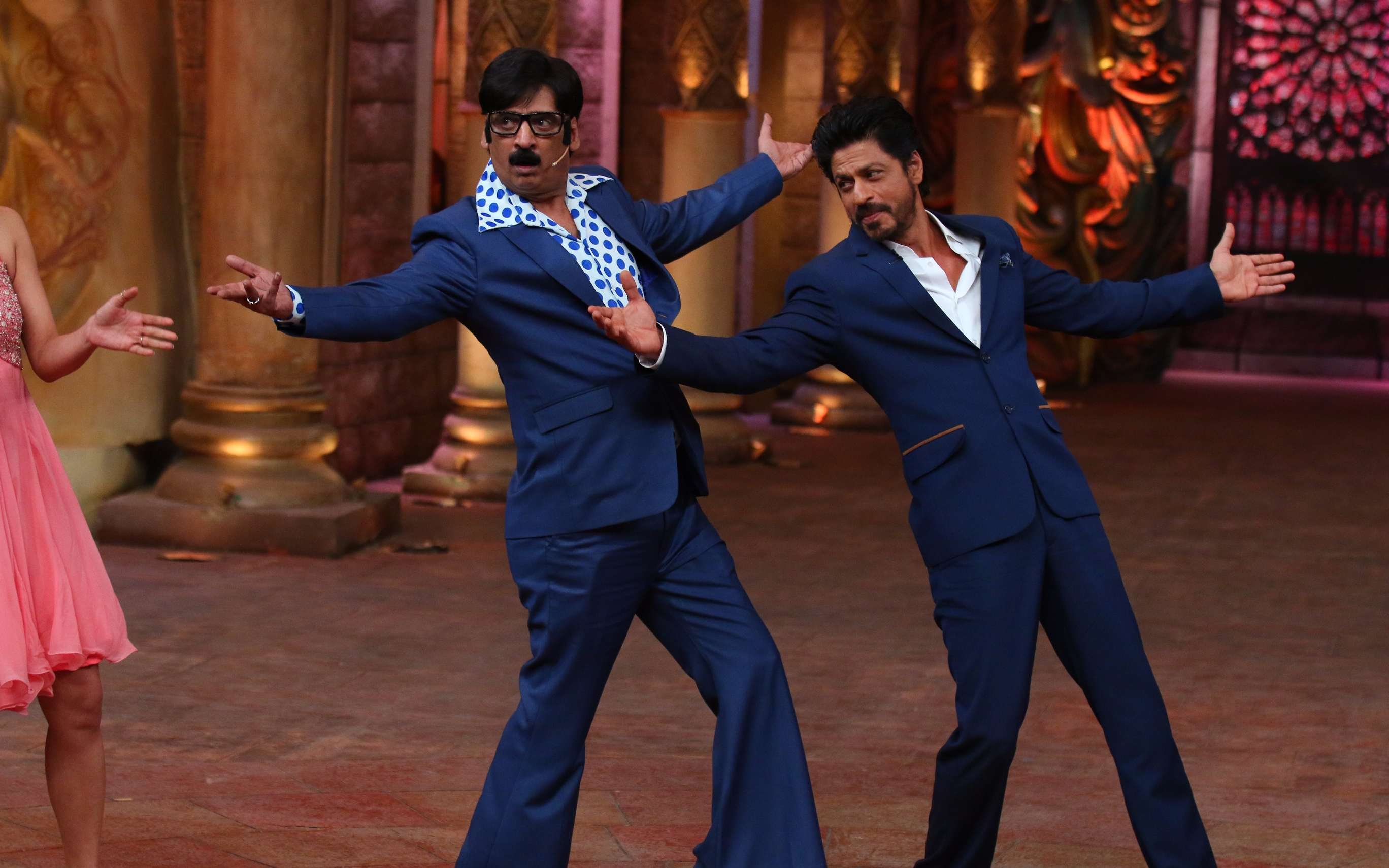 Two performers in blue suits on stage during "Budha Ghar Par Hai" comedy evening.