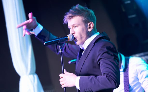 Singer performing on stage with a microphone.