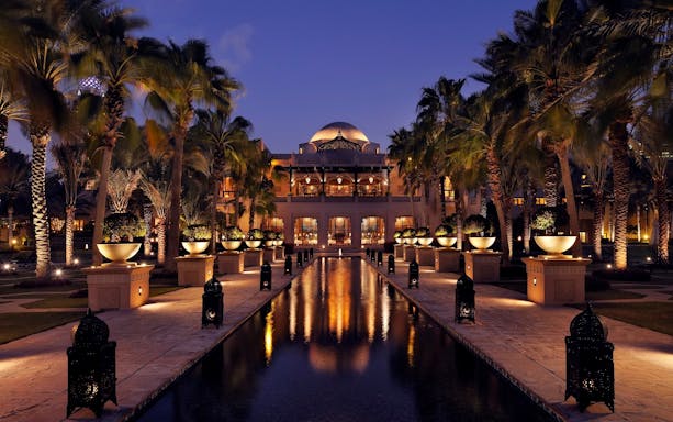 Elegant venue with palm trees and lit pathway for Christmas Gala Concert.