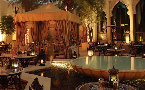 Elegant outdoor seating with lanterns and a fountain at a Christmas Gala Concert venue.