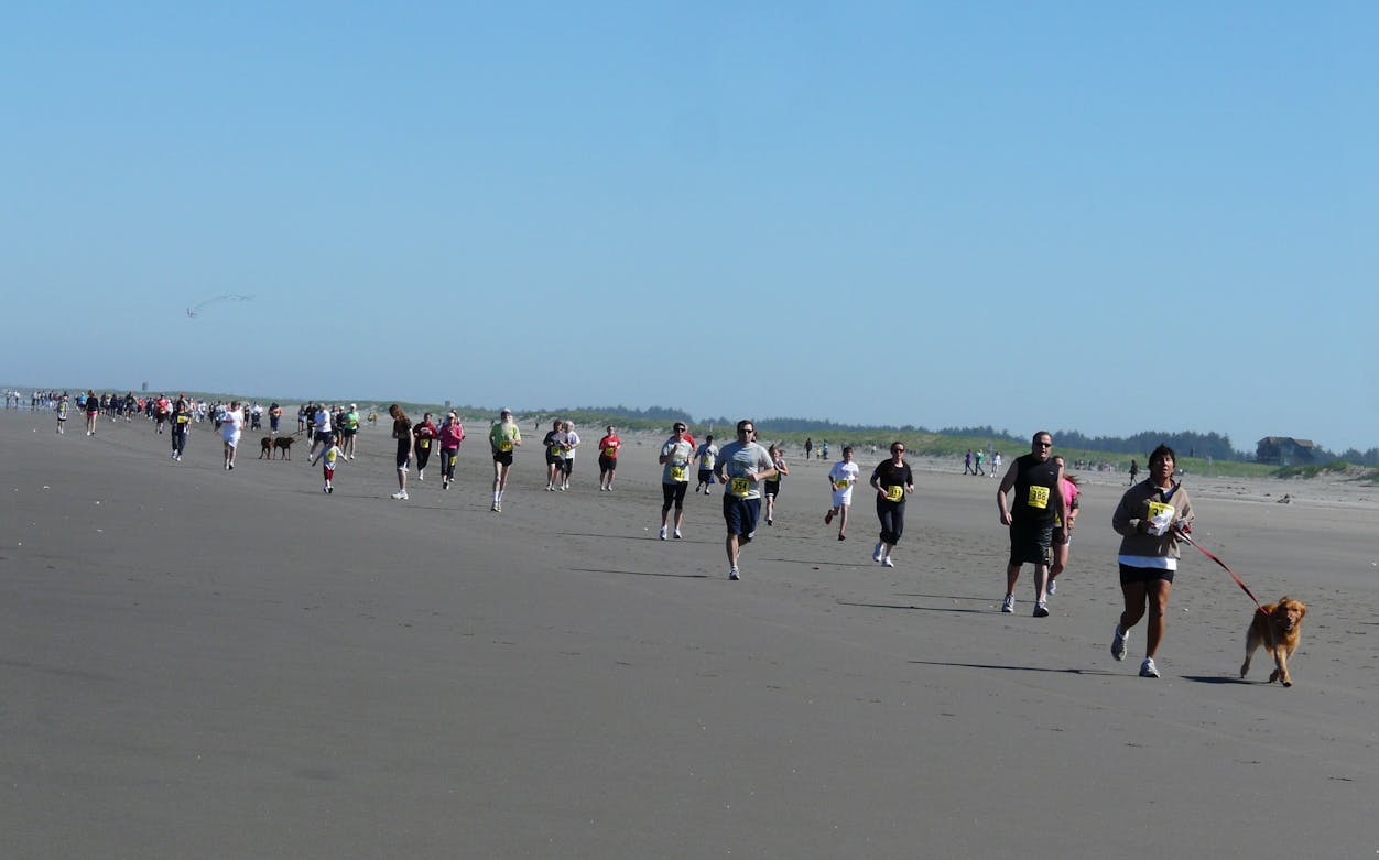 Participants running on a beach during The Unity Run Dubai 2016.