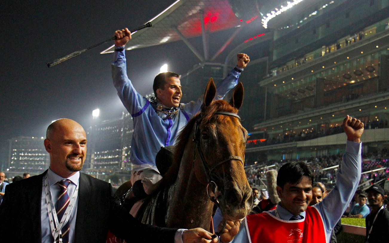 Jockey celebrating victory at Meydan Racecourse in Dubai.