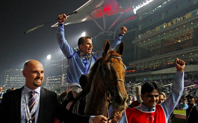 Jockey celebrating victory at Meydan Racecourse in Dubai.