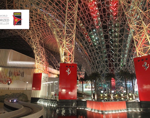 Ferrari World Abu Dhabi interior with red and steel architecture, featuring palm trees and water features.