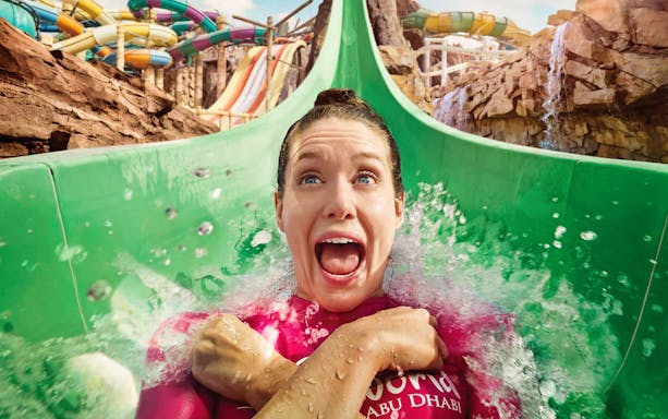 Person enjoying a water slide at Yas Waterworld, Abu Dhabi.