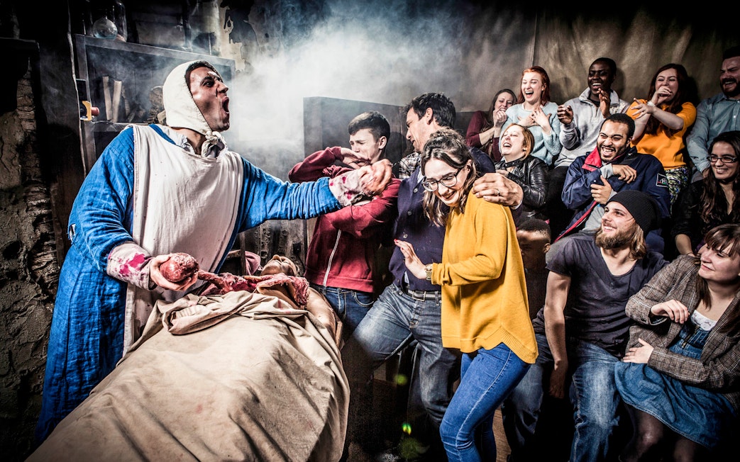 Group reacting to a theatrical performance at London Dungeon.