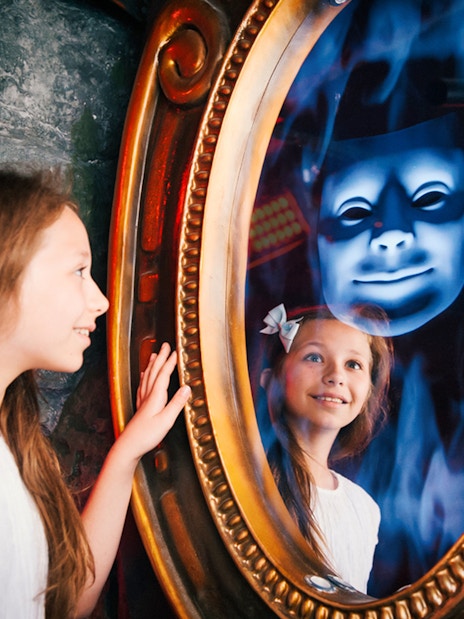 Child interacting with magic mirror at Shrek's Adventure London.