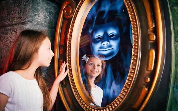 Child interacting with magic mirror at Shrek's Adventure London.