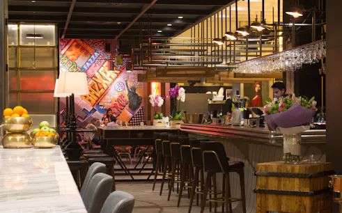 Bar interior with colorful graffiti wall and patrons enjoying a Prohibition Brunch Party.