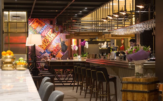 Bar interior with colorful graffiti wall and patrons enjoying a Prohibition Brunch Party.