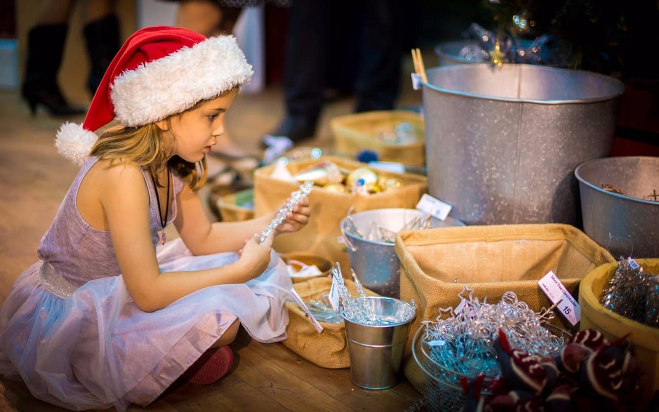 Child exploring festive decorations at Dubai Winter Festival 2016.