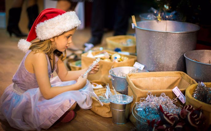 Child exploring festive decorations at Dubai Winter Festival 2016.