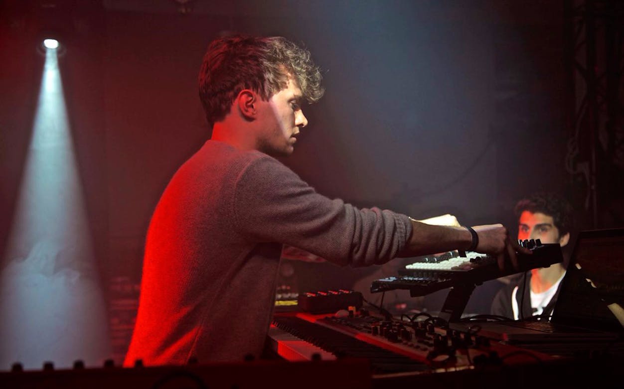 Musician performing live at Plus Minus Arena with electronic equipment.