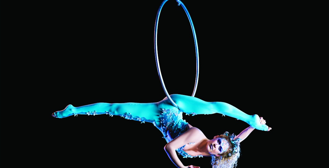 Aerial performer in turquoise costume on hoop, Cirque du Soleil: Amaluna.