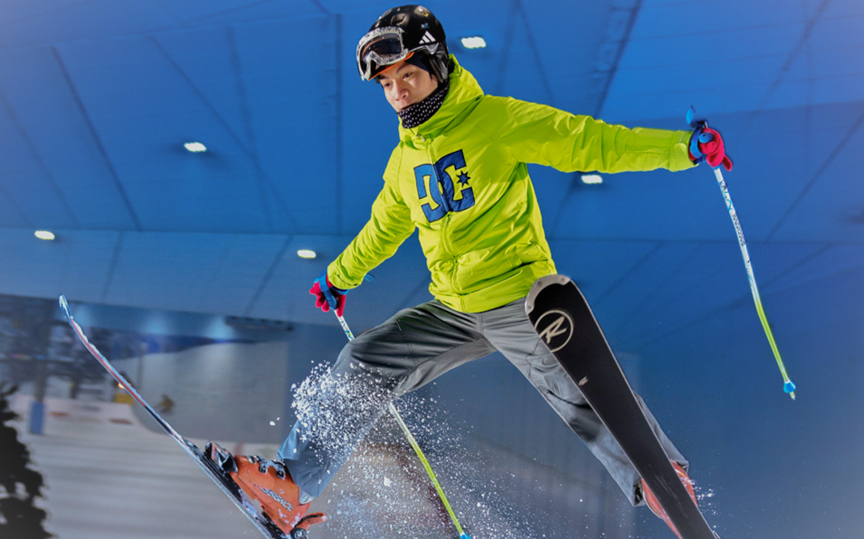Snowboarder mid-jump during 2-hour session at Ski Dubai indoor slope.