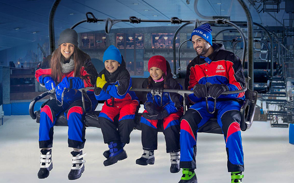 Family on ski lift at Ski Dubai indoor snow park.