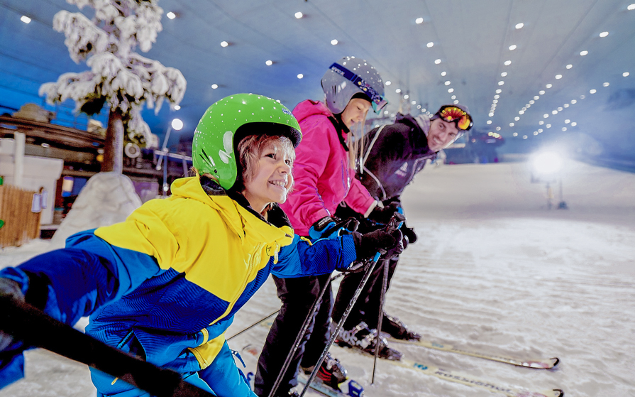 Snowboarders preparing for a session at Ski Dubai indoor slope.