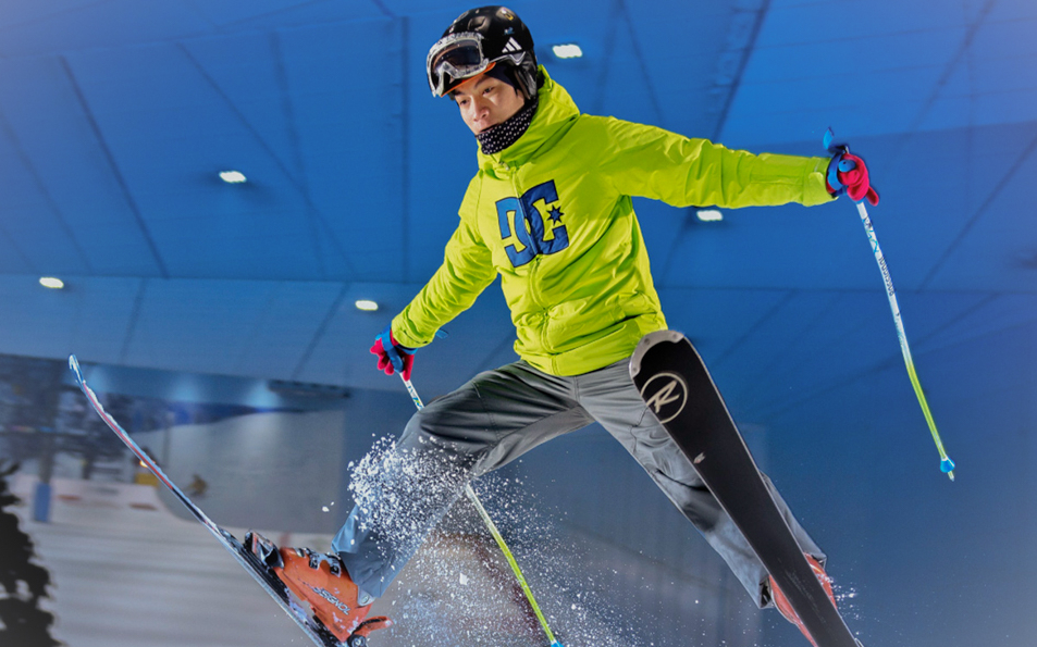 Skier mid-air during a jump at Ski Dubai indoor slope session.