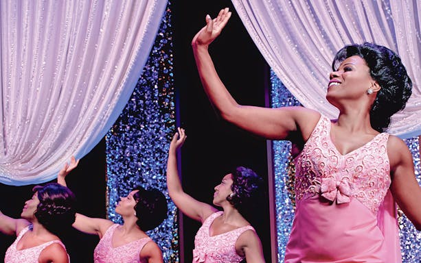 Performers in pink dresses on stage during Beautiful: The Carole King Musical.