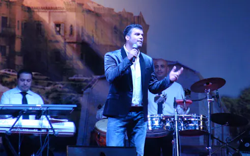 Singer performing on stage with musicians during Fares Karam & Maya Diab concert.