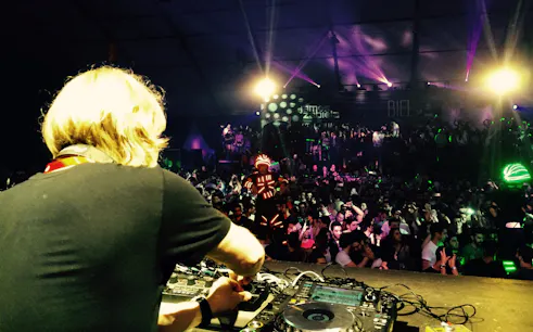 DJ performing at Back2Basics NYE event with James Zabiela, vibrant crowd and light show.