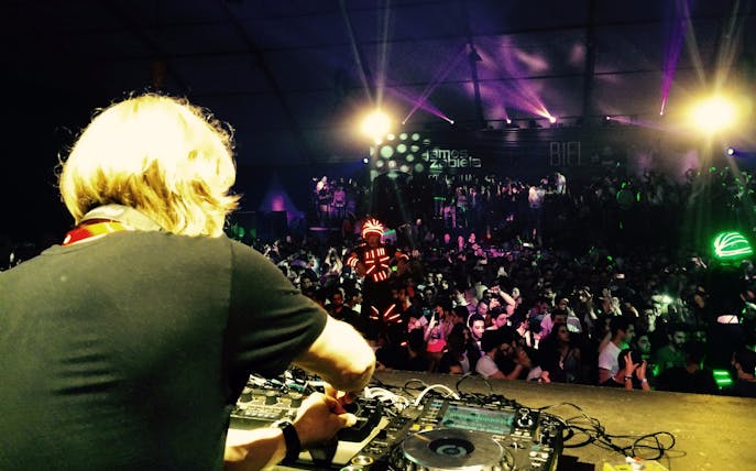 DJ performing at Back2Basics NYE event with James Zabiela, vibrant crowd and light show.