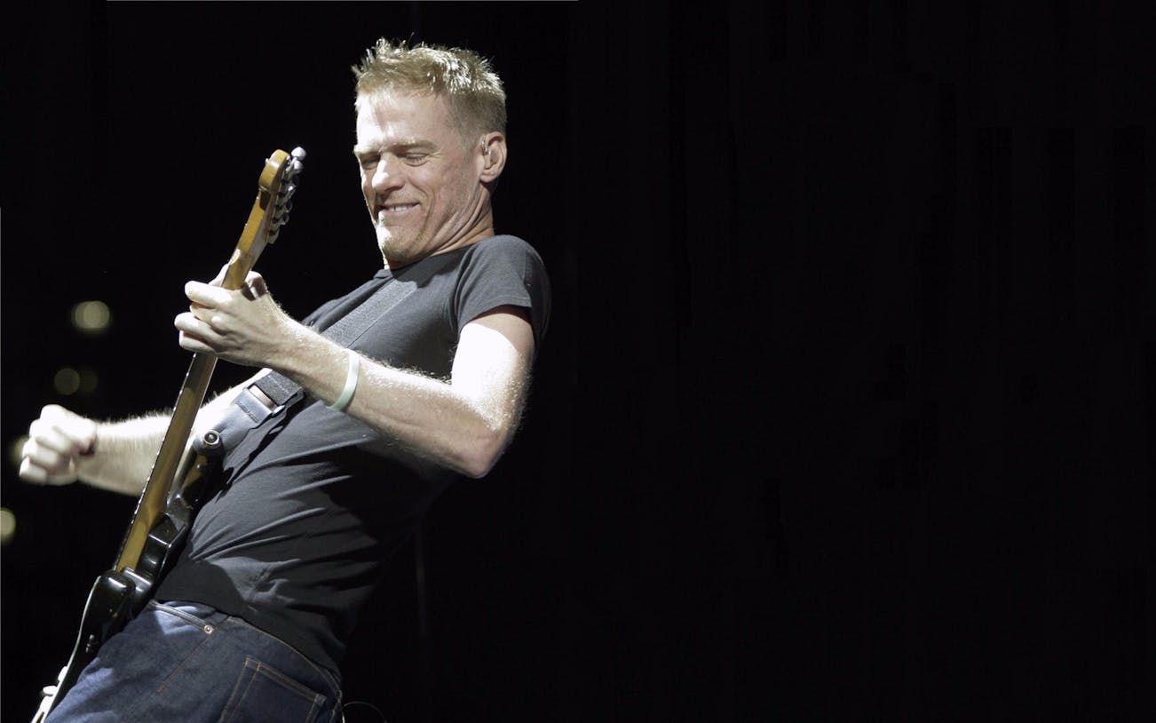 Bryan Adams performing live on stage during his World Tour concert.
