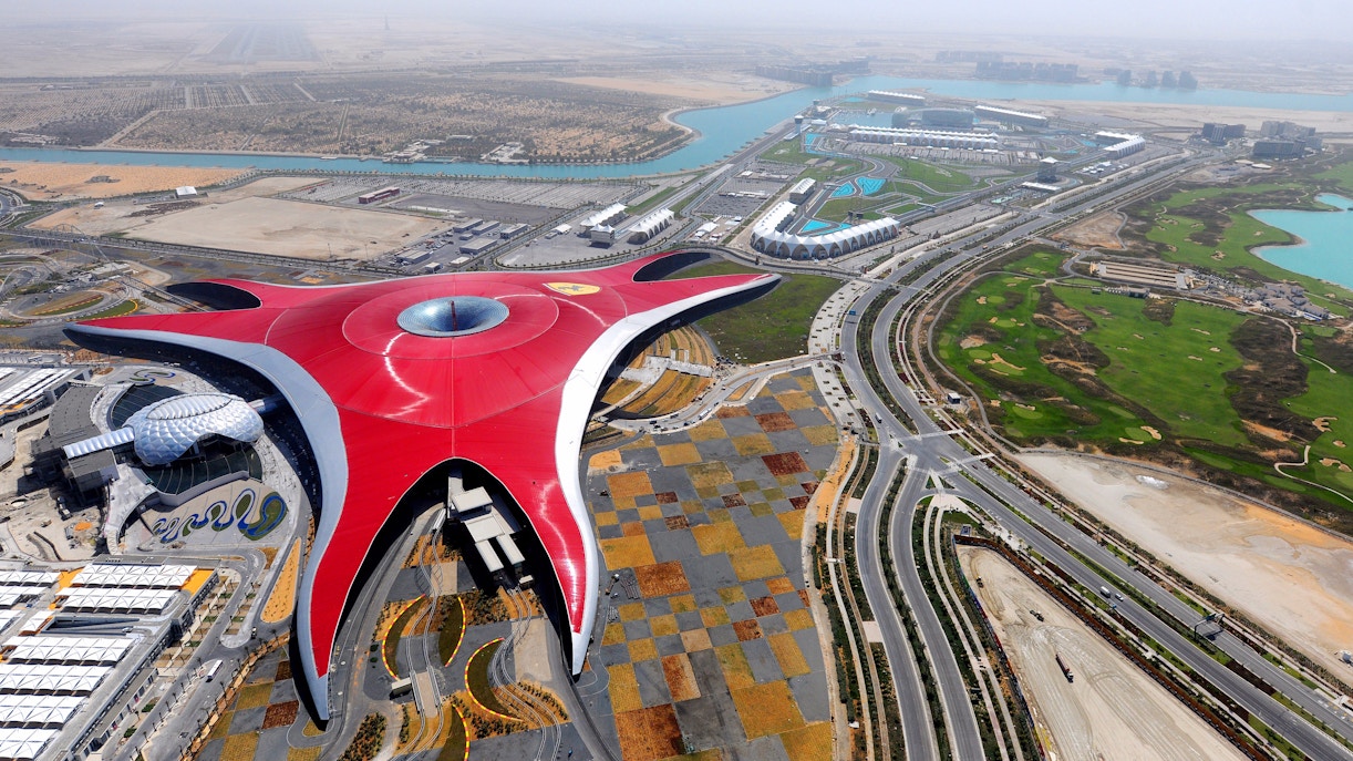 Aerial view of Ferrari World in Abu Dhabi, featuring its iconic red roof, seen during a Seawings Seaplane Tour.
