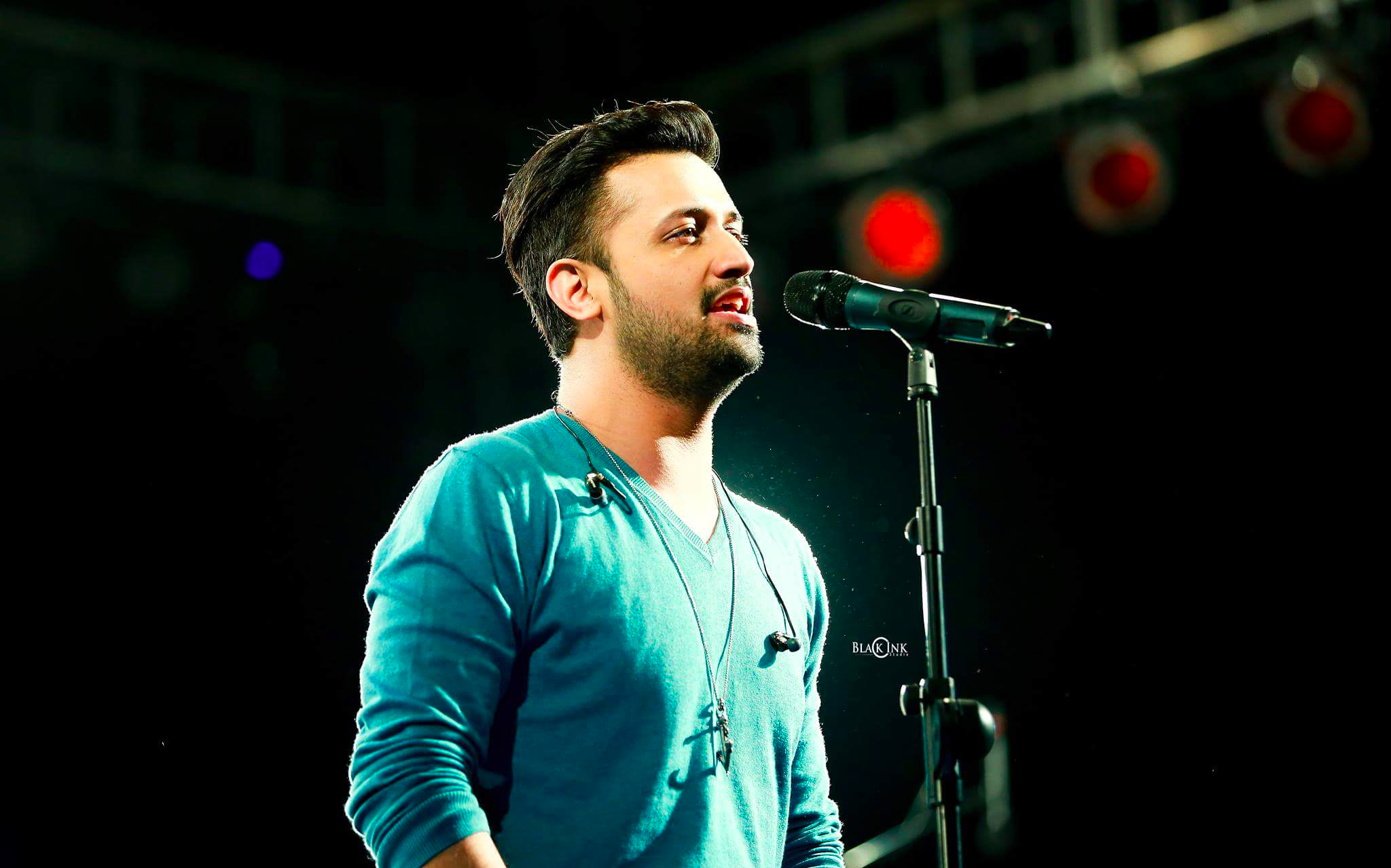Singer performing live on stage with microphone.