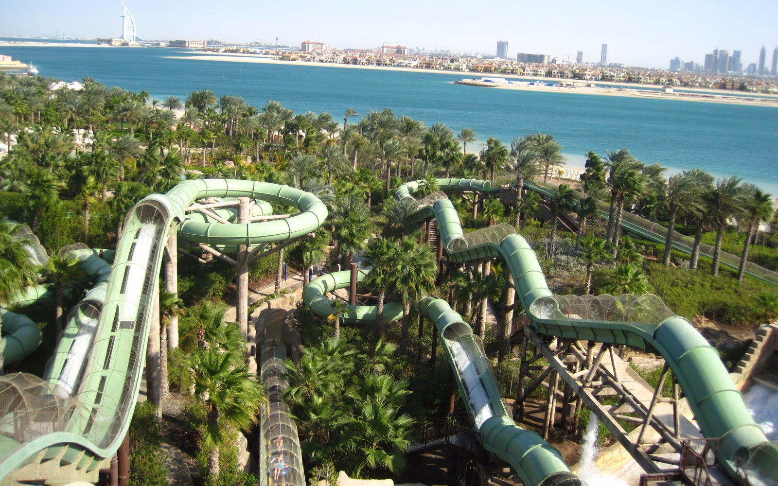Aquaventure Waterpark slides with Dubai skyline and sea in the background.