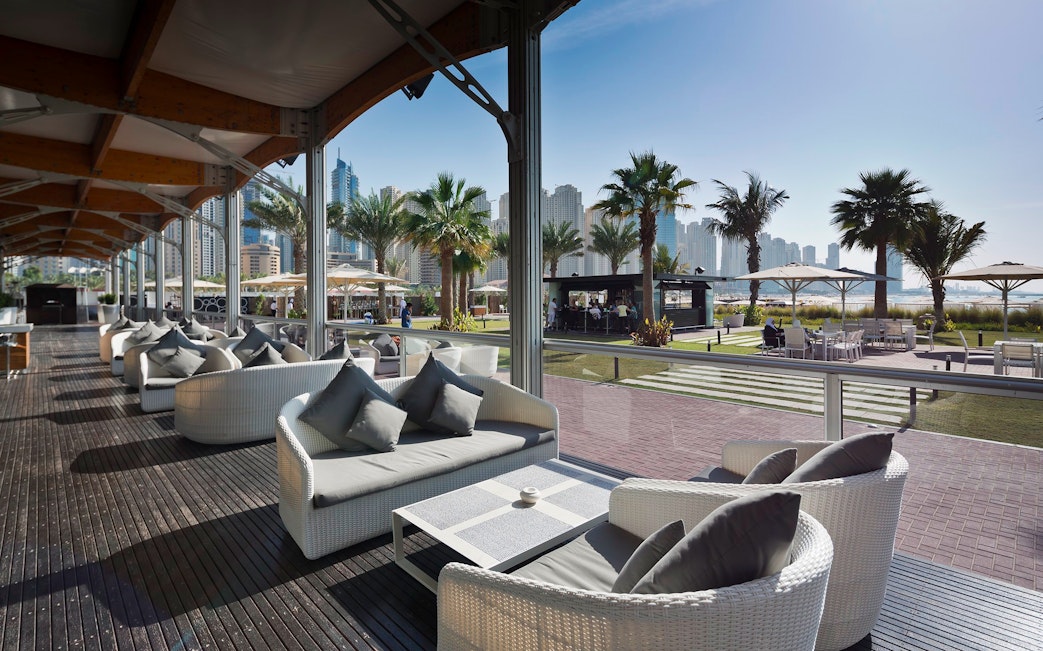 Outdoor lounge area at Zero Gravity Dubai with city skyline in the background.