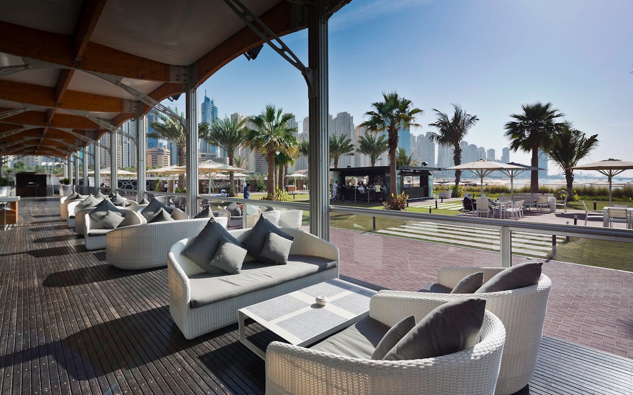 Outdoor lounge area at Zero Gravity Dubai with city skyline in the background.